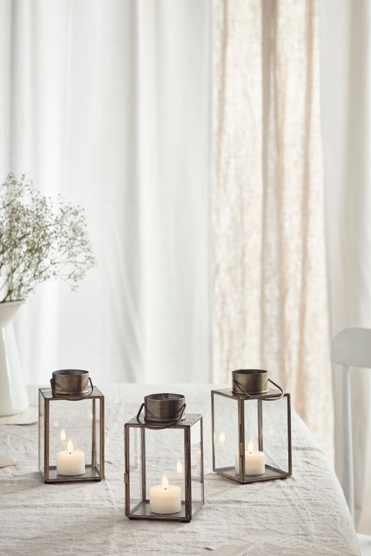3 candle lanterns in a linen table cloth.