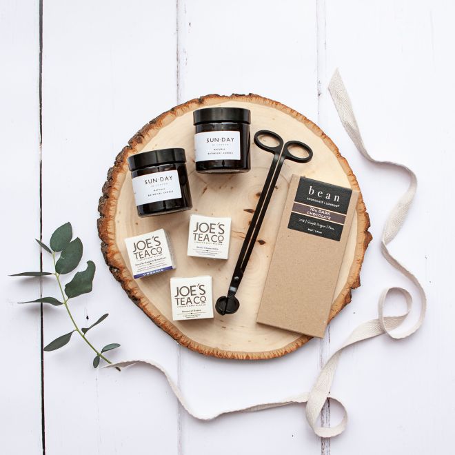 Contents of a gift box - tea, candle and a wick trimmer.