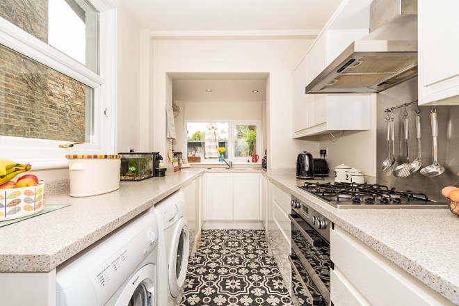 Galley kitchen in a Victorian home with a statement floor.